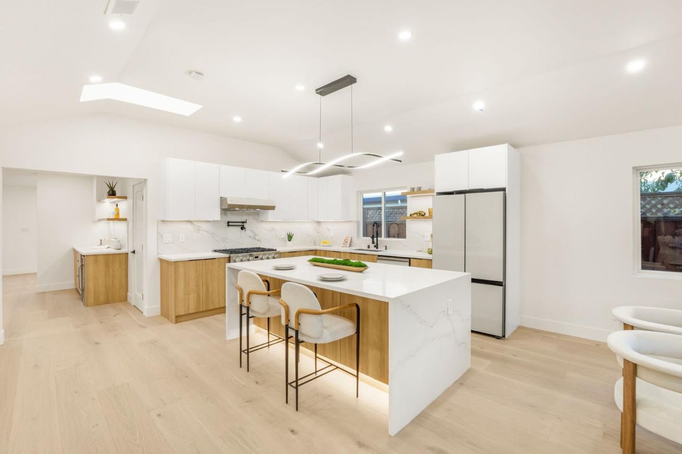 Open kitchen with waterfall quartz island — Sunnyvale down-to-stud renovation